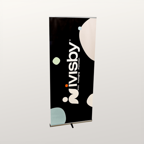 Rollup med iVisby Tryckeri-design i svart med färgade grafiska former, monterad i aluminiumställ.